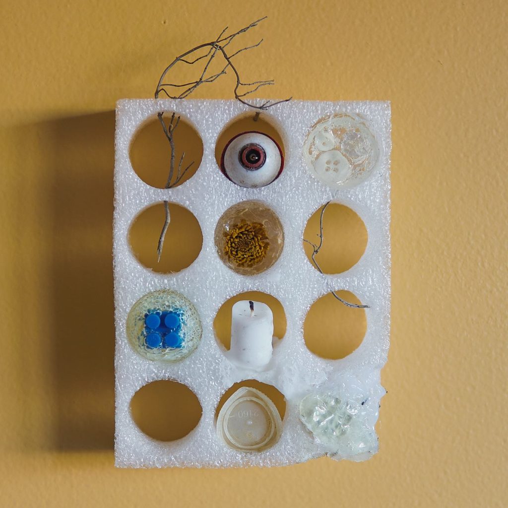 Cluster, 2023, styrofoam, bottle caps, candle, lego, bobber, twigs, acrylic medium